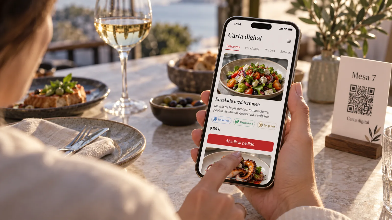 Una clienta pide desde su mesa escaneando el QR, con la carta digital abierta en el móvil