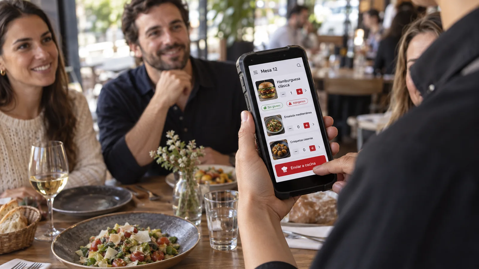 Un camarero toma el pedido de una mesa con la PDA y lo envía a cocina